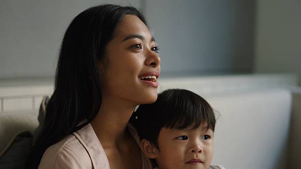 Mother and son sitting closely together at home